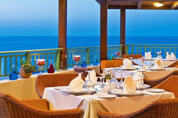 Terrasse des Giannoulis Grand Bay Beach Resorts mit Blick auf den Ozean.
