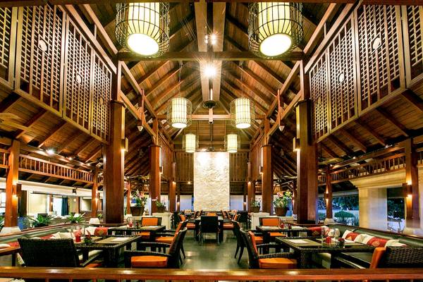 Innenansicht des Restaurants im Pavilion Samui Villas & Resort mit Holzdecken und Tischgedecken.