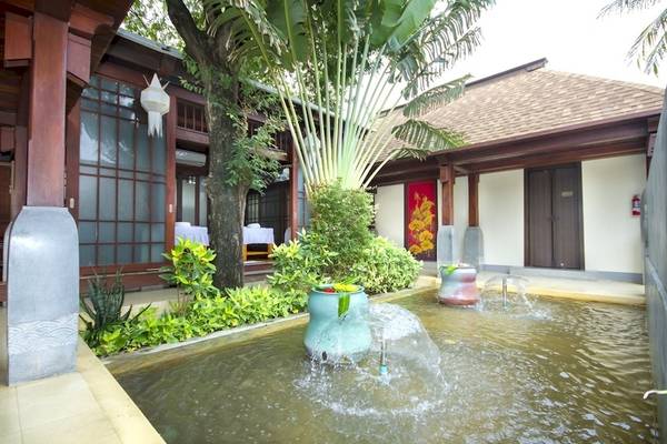 Außenbereich des Pavilion Samui Villas & Resort mit einem Brunnen und einer Terrasse.
