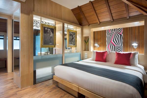 Schlafzimmer im Pavillon Samui Villas & Resort mit Holzboden, Bett, Spiegel und Golfbildern