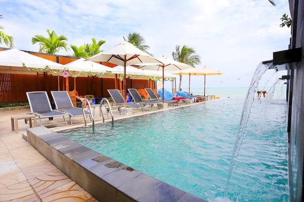 Außenpool mit Sonnenliegen und Sonnenschirmen im Pavilion Samui Villas & Resort.