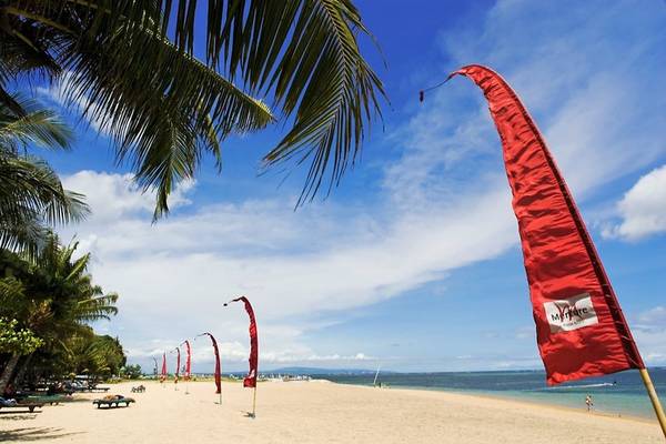 Rote Fahnen und Palmen am Strand des Mercure Resort Sanur
