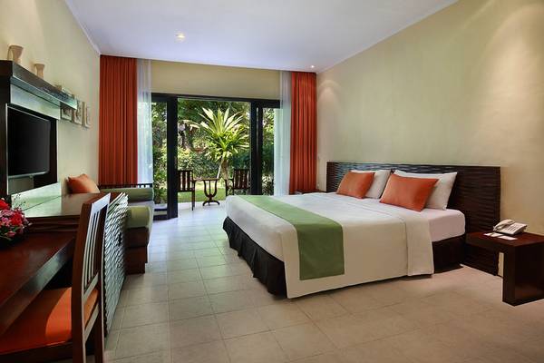 Hotelzimmer im Mercure Resort Sanur mit Bett, Fernseher und Balkon.