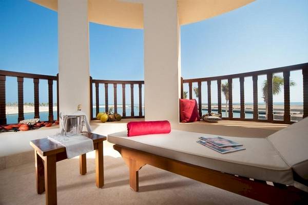 Blick vom Balkon des Juweira Boutique Hotels mit Loungemöbeln, Kissen und Meersicht
