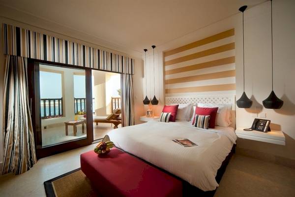 Schlafzimmer im Juweira Boutique Hotel mit Bett, Früchtekorb, Telefon und Aussicht auf den Balkon