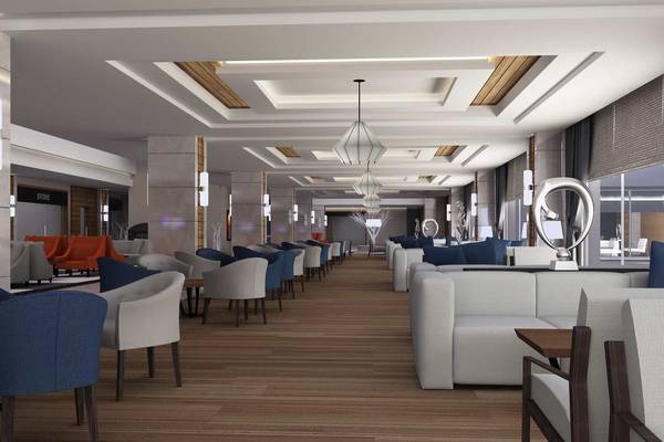 Innenansicht der Lobby des Side Sunport Hotel & Spa mit Holzboden, modernen Möbeln und Kunstwerken.