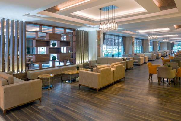 Lobby des Side Sunport Hotel & Spa mit modernen Möbeln und Holzböden.