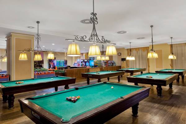 Billardsaal im Kremlin Palace Hotel mit mehreren Billardtischen und Spielgeräten.