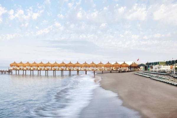 Außenbereich des Kremlin Palace Hotels mit Sonnenschirmen und Liegestühlen am Strand