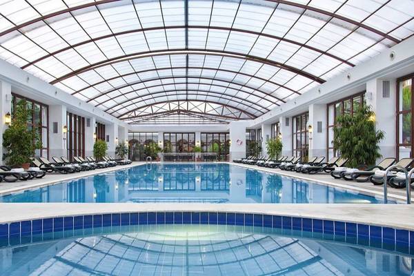 Innenpool des Kremlin Palace Hotels mit Lounge-Liegestühlen und Glasdach