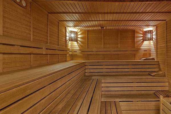 Innenansicht der Sauna im Kremlin Palace Hotel mit hölzernen Bänken und Beleuchtung.
