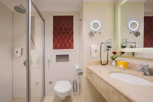 Badezimmer des Kremlin Palace Hotels mit Dusche, Toilette und Waschbecken.