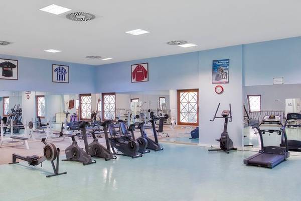 Fitness-Center im Kremlin Palace Hotel mit verschiedenen Trainingsgeräten und Spiegeln.