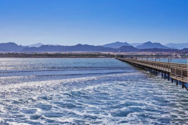 Foto eines Piers im Meer mit Bergen im Hintergrund am Jaz Mirabel Beach Hotel