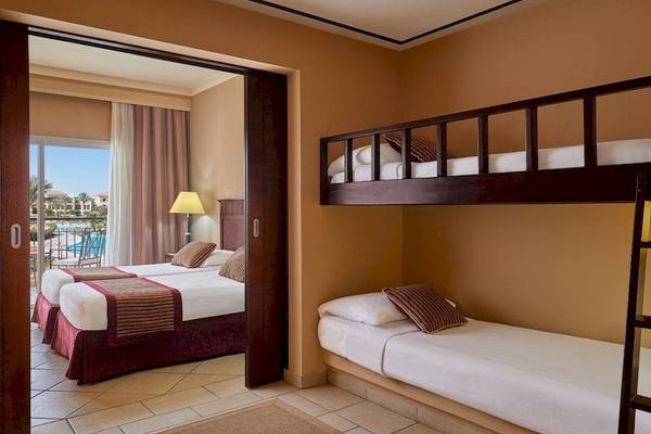 Doppelzimmer im Jaz Mirabel Beach Hotel mit zwei Betten und einem Etagenbett.