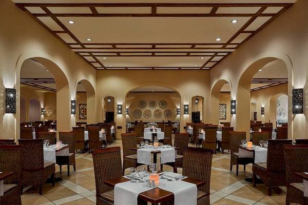 Innenansicht des Jaz Mirabel Beach Restaurants mit gedeckten Tischen und Stühlen.