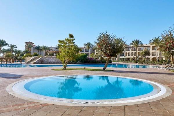 Außenpool im Jaz Mirabel Beach Hotel mit gepflastertem Bereich und Palmen