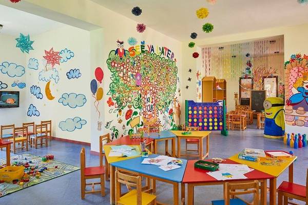 Kinderzimmer im Jaz Mirabel Beach Hotel mit bunten Wandgemälden, Tischen und Stühlen für Aktivitäten.