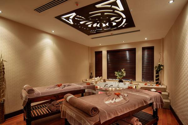 Saunaraum im Sunrise Queen Luxury Hotel mit zwei Massagetischen und einer Badewanne.