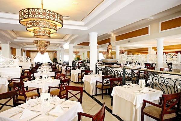 Innenansicht des Restaurants des Bahia Principe Luxury Esmeralda Hotels mit gedeckten Tischen und eleganter Beleuchtung.