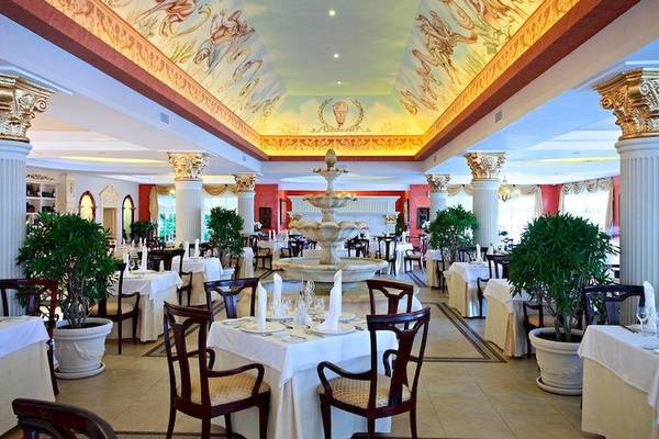 Innenansicht des Restaurants des Bahia Principe Luxury Esmeralda Hotels mit Tisch, Stühlen, Brunnen und Pflanzen.