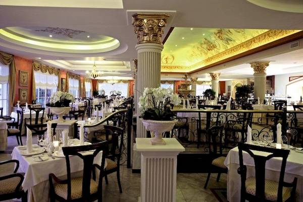 Innenansicht des Restaurants im Bahia Principe Luxury Esmeralda Hotel mit gedeckten Tischen, eleganten Stühlen und dekorativen Säulen.
