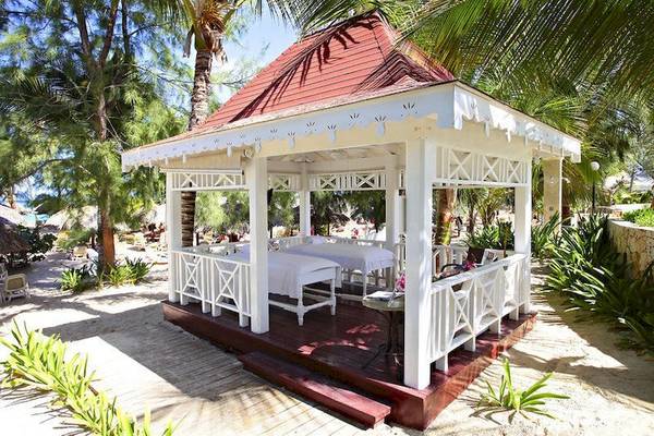 Massagepavillon im Bahia Principe Luxury Esmeralda Hotel, umgeben von Pflanzen und Bäumen.
