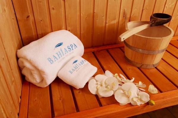 Saunabereich im Bahia Principe Luxury Esmeralda mit zwei Handtüchern, einem Holzeimer und Blumen