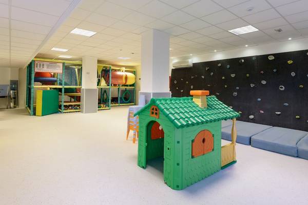 Spielbereich für Kinder im Leonardo Royal Hotel Ibiza Santa Eulalia mit Kletterwand, Spielhaus und Spielzeug.