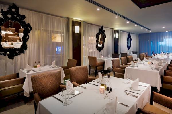 Innenbereich des Restaurants im Hard Rock Hotel Cancun mit eleganten Tischen und Stühlen.