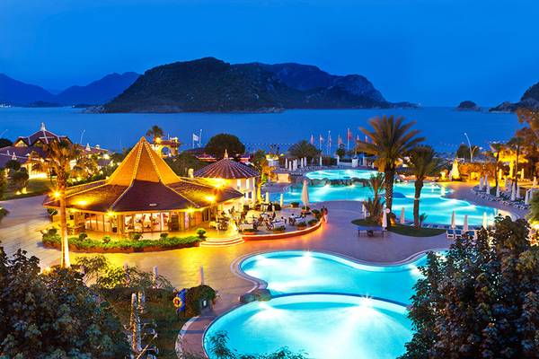 Abendlicher Blick auf das Marti Resort mit Pools und Meerblick.