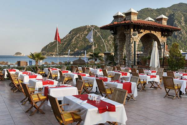 Außenbereich des Marti Resorts mit vielen Tisch und Stühlen, Meer und Berge im Hintergrund