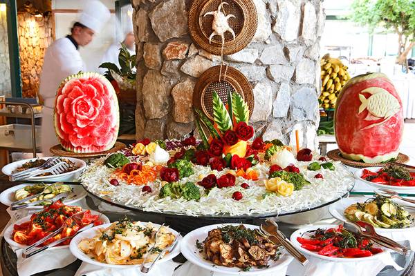 Buffet im Marti Resort mit verschiedenen Gerichten, darunter Obst und Gemüse, sowie Wassermelonen in Fischform.