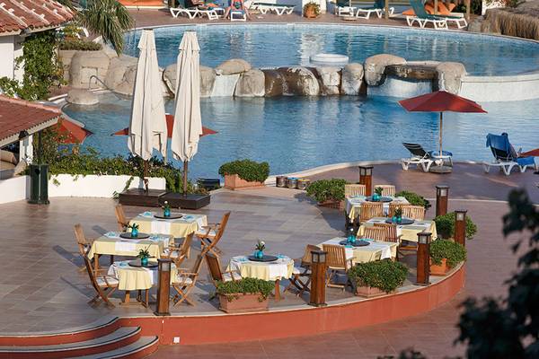 Terrasse des Marti Resorts mit Schwimmbad und runden Tischen mit Sonnenschirmen.
