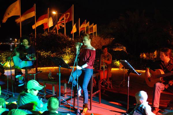 Eine Gruppe Musiker spielt auf der Bühne im Marti Resort, während eine Frau singt.