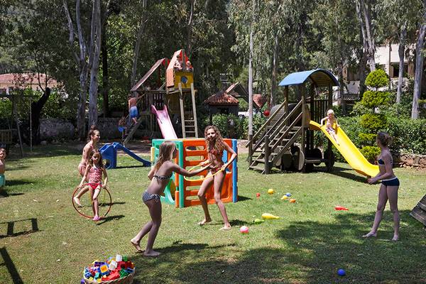 Kinder spielen auf einem Spielplatz im Garten des Marti Resorts.