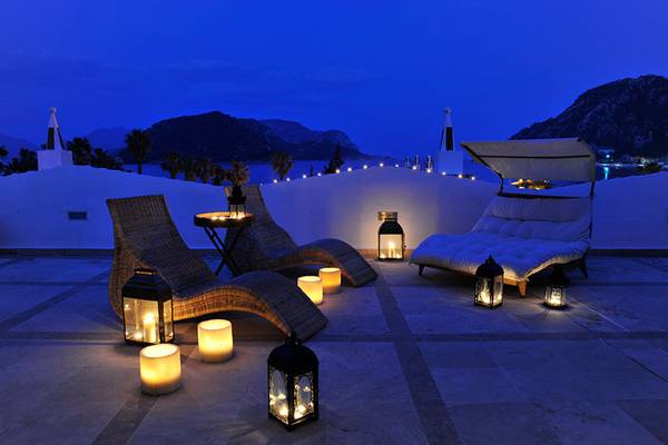 Abendterrasse im Marti Resort mit illuminierten Loungemöbeln und Kerzen bei Nacht