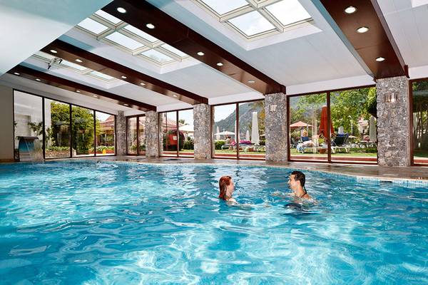 Zwei Personen schwimmen im großen Innenpool des Marti Resorts.