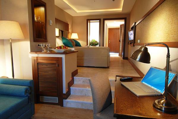 Marti Resort Hotelzimmer mit Arbeitsbereich, Bett, Sofa und Schreibtisch.
