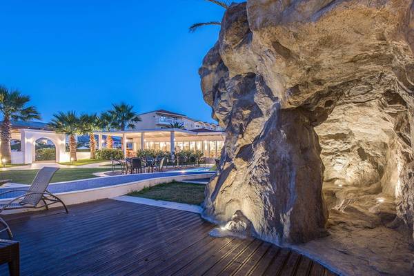 Außenbereich des Galaxy Beach Resorts bei Nacht mit Beleuchtung und Loungestühlen.