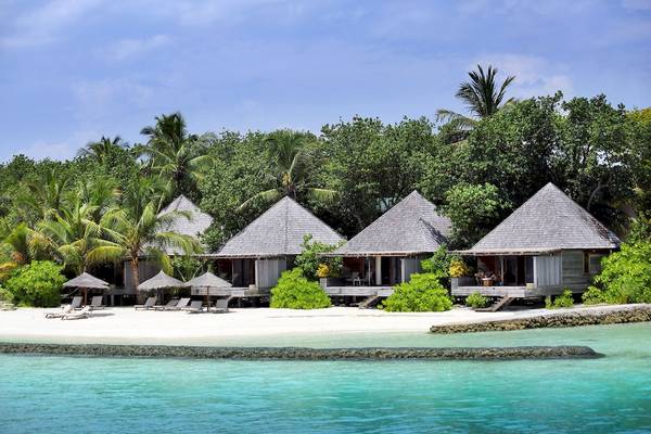 Foto von mehreren Hütten am Strand des Gangehi Island Resorts