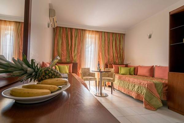Zimmer im Galaxy Beach Resort mit Sofabett und Frühstücksplatte mit Ananas und Bananen.