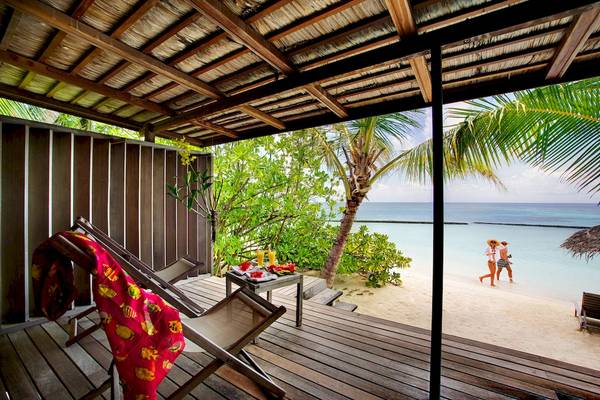 Aussicht auf den Strand mit einer Holzterrasse vom Gangehi Island Resort.