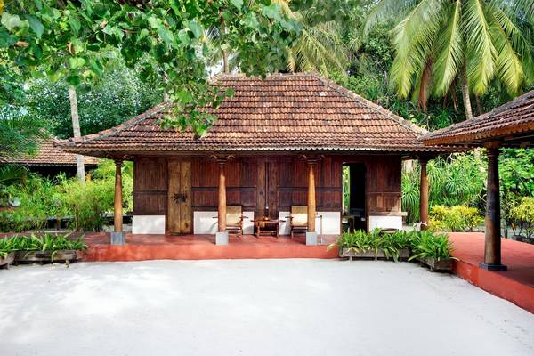 Außenansicht des Gangehi Island Resorts mit traditionellem, hölzernem Gebäude und roter Veranda.
