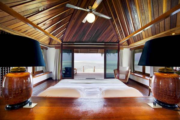 Schlafzimmer im Gangehi Island Resort mit Blick auf das Meer und eine Veranda.