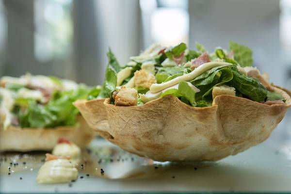 Salat in einer gebackenen Brotschalen serviert, mit knackigem Salat, Croutons und Schinken.