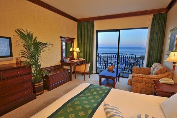 Ein elegantes Hotelzimmer im Grand Hotel Gozo mit Blick auf das Meer vom Balkon.