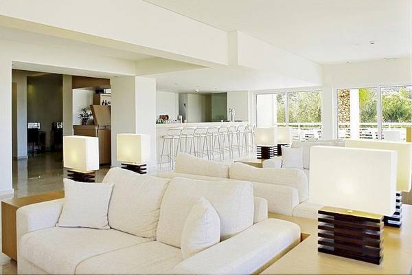 Lounge-Bereich des Lindos White Hotel & Suites mit weißen Möbeln und Lampen.