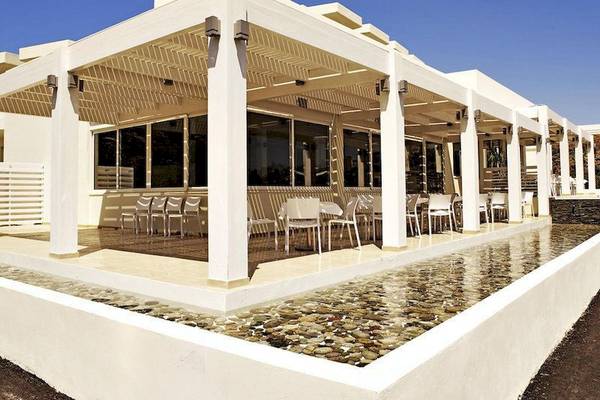 Terrasse des Lindos White Hotel & Suites mit Tischen und Stühlen unter einem weißen Pavillon