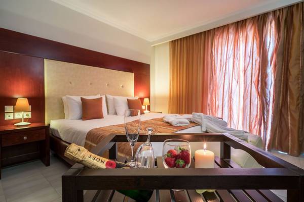 Hotelzimmer des Galaxy Beach Resorts mit Bett, Tisch, Weinglas und Kerzen.